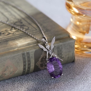 Detailed view of an oval purple gemstone fairy pendant on a vintage book