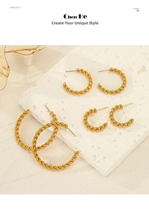 Three sizes of gold twisted C-shape hoop earrings displayed on white textured stone board