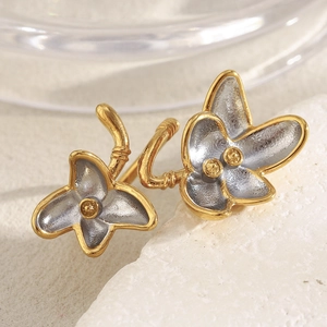 Close-up of two-tone 18K gold plated flower ring on a natural white stone texture