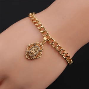 Detail of gold Cuban chain bracelet featuring a Virgin Mary pendant with white zircons