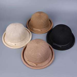 Detail view of knitted cloche hats in four neutral colors featuring delicate bow accents