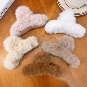 Set of 5 fuzzy faux fur claw clips in neutral tones arranged on a wooden table