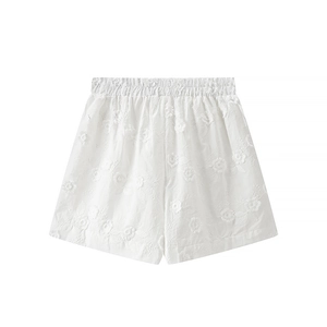 Detailed close-up of white women's shorts with 3D floral embroidery and elastic waistband