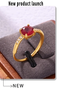 Detailed close-up of rose red zircon gold ring with 4-prong setting and pavé accents