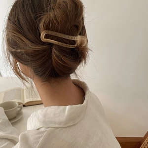 Elegant matte beige shark hair claw clip for women shown on a model in a natural setting