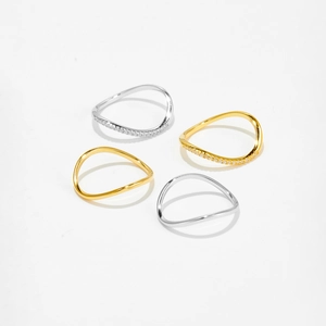 Detailed view of wave-shaped S925 silver rings in gold and silver with zircon accents