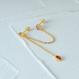 Macro shot of 925 silver chain earrings with colorful zircon and 18K gold plating