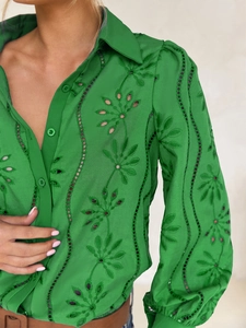 Close-up of green hollow embroidery shirt featuring intricate leaf patterns and wavy textures