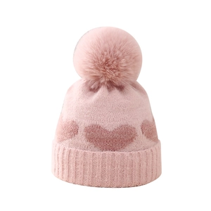 Pink winter knit baby hat with heart jacquard pattern and large fluffy pompom detail