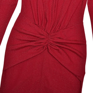 Gros plan d'une robe rouge à paillettes avec nœud élégant et texture de tissu scintillante