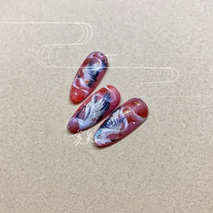 Détail de stickers à ongles rouges de style chinois avec motifs de grues et nuages