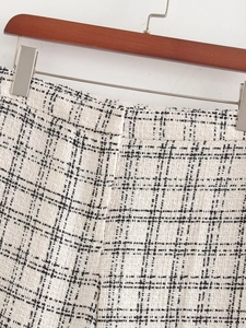 Close-up of elegant black and white tweed texture on high-waist women's vest and trousers set