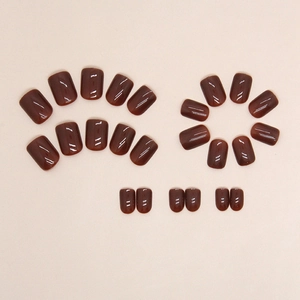 Glossy reddish-brown press-on nails set in short square round shape on beige background