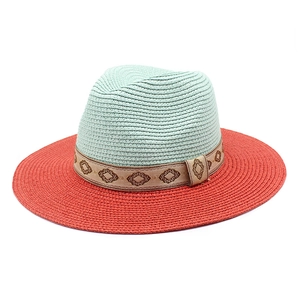 Two-tone woven panama straw hat in mint green and coral orange with ethnic patterned band