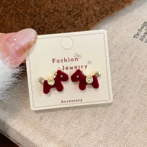 Close-up of red flocked pony stud earrings with 18K gold-plated metal details