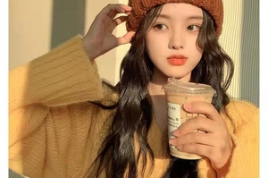 Close-up of a warm chunky knit beanie and yellow V-neck sweater in soft golden hour sunlight