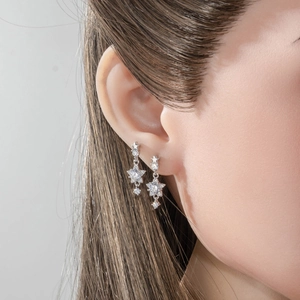 Elegant silver star and rhombus drop earrings with sparkling cubic zirconia on female model