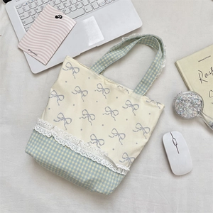 Detailed lace trim and blue bow patterns on a canvas tote bag for daily commute