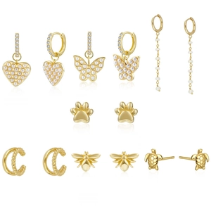 Makroansicht von Gold-Schmuckset mit Zirkon-Schmetterling, Herz-Anhängern und Perlen