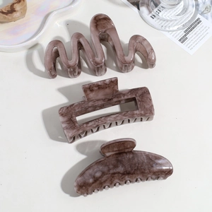 Close-up of tortoise shell hair clips in wavy and rectangular hollow designs