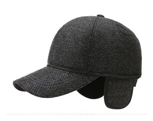 Detail der dunkelgrauen Winter-Baseballkappe mit Ohrenklappen und Metall-M-Logo