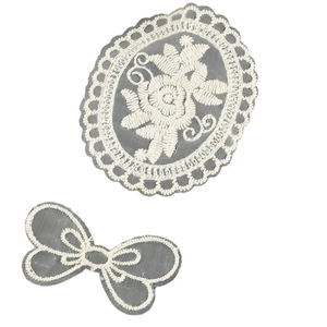 Off-white embroidered lace patches with floral oval and bow designs on grey mesh background