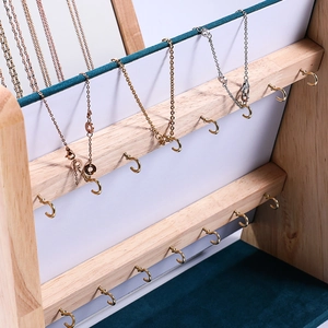 Three-tier wooden jewelry display stand with metal hooks and green velvet backing