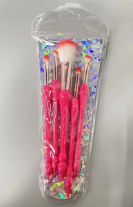 Detail view of 5-piece pink makeup brush set in transparent packaging with holographic card