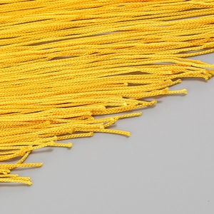 Détail macro de franges jaune vif avec une texture de corde tressée complexe
