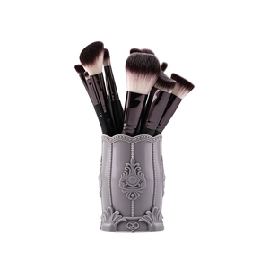 Detailed view of makeup brushes with black handles and grey embossed storage case