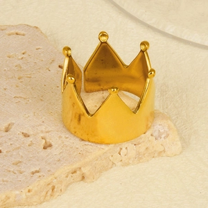 Detail of 18k gold plated crown ring with polished beads on natural stone surface