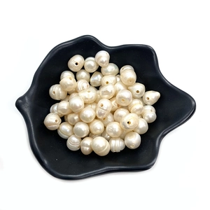 Bulk white irregular natural freshwater pearls in a black dish for DIY jewelry making