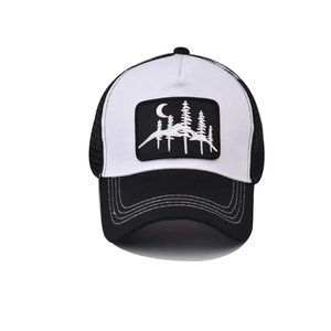 Close-up of moon and forest embroidery on a contrast trucker hat with breathable mesh