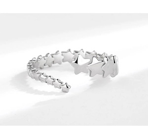 Macro detail of silver ring featuring interconnected star patterns on a clean background