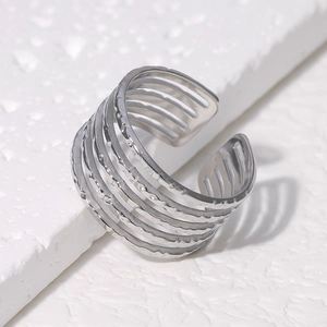 Detailed view of silver minimalist multi-layer open ring on textured stone surface