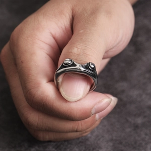 Detailed close-up of a vintage silver frog ring with artistic animal design texture