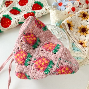 Detailed macro view of handmade crochet floral headbands with strawberry and sunflower patterns