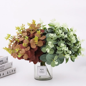 Gros plan de feuilles d'eucalyptus vertes et brun-rouge dans un vase en verre clair