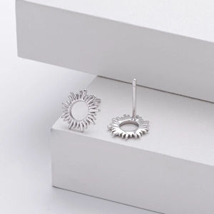 Macro detail of sunburst hollow s925 silver stud earrings on white geometric steps