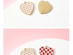 Detailed macro view of heart-shaped checkered enamel charms in pink and red gold finish