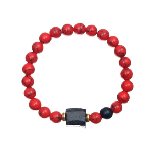 Detailed view of red stone beads with black accents and golden spacers on a beaded bracelet