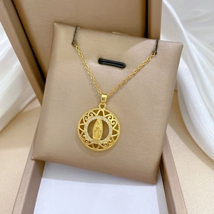 Close-up of gold titanium necklace featuring a Virgin Mary medallion with crystal halo