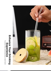 Primer plano de vaso de vidrio estriado con tapa de bambú y pajita para bebidas frescas