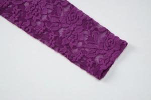Détail de la texture de dentelle florale violette et de la finition du revers de manche