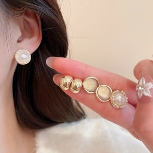 Detail of vintage gold pearl stud earrings set shown on model for elegant daily wear
