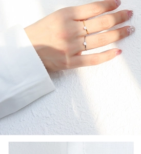 Detail of minimalist gold and silver rings with small diamonds worn on fingers