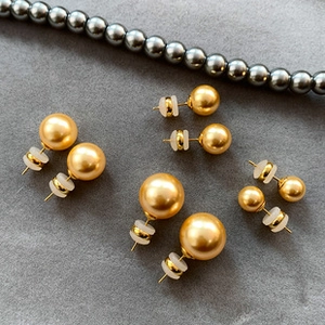 Detailed view of assorted gold pearl stud earrings with secure silicone backings