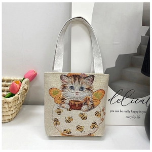 Close-up of cat and honey pot embroidery on beige canvas tote bag details