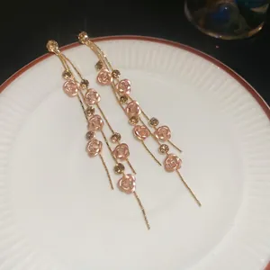 Boucles d'oreilles pendantes dorées avec fleurs roses et cristaux au style raffiné