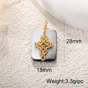 Detailed view of golden cross pendant with green gem on rectangular abalone shell base